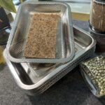 Coco coir growing mat laid inside a perforated stainless steel microgreen tray